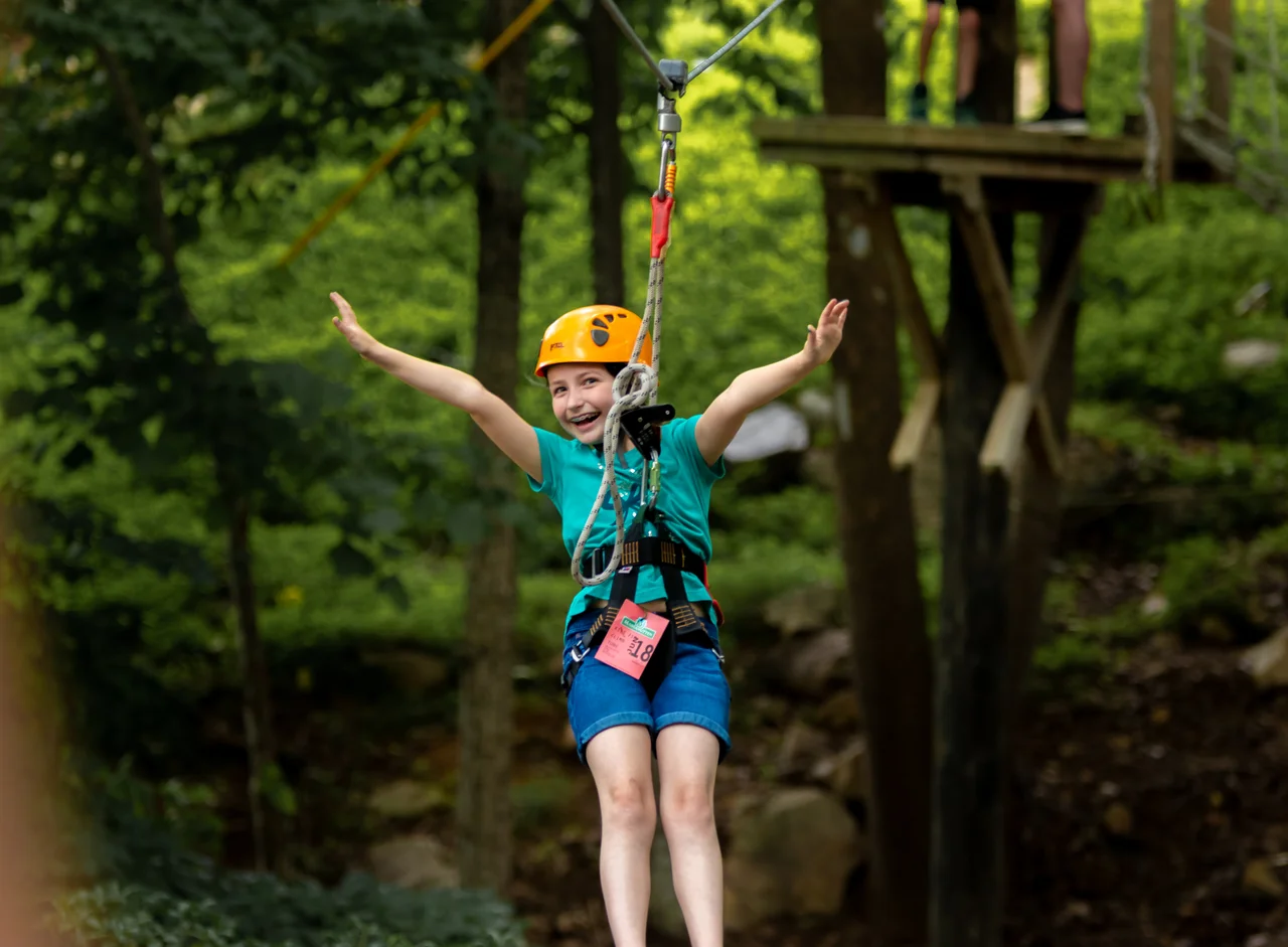 Massanutten zipline child riding with arms out